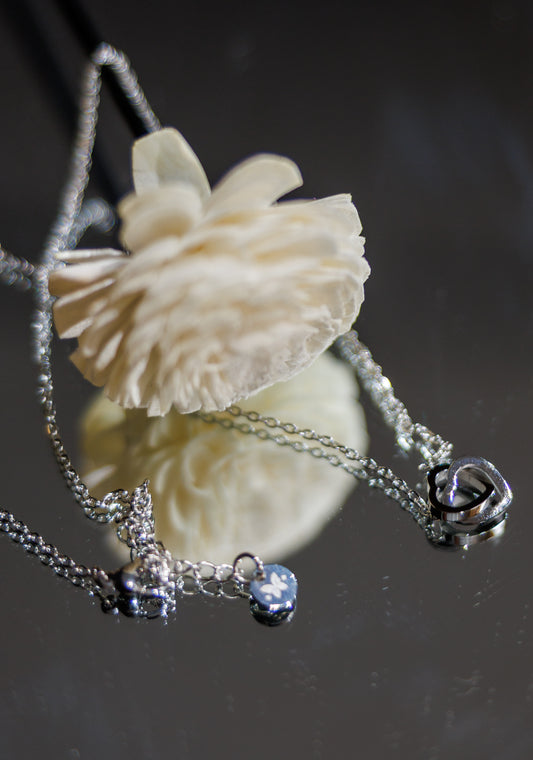 “Elegant stainless steel necklace featuring two interlocking hollow hearts.