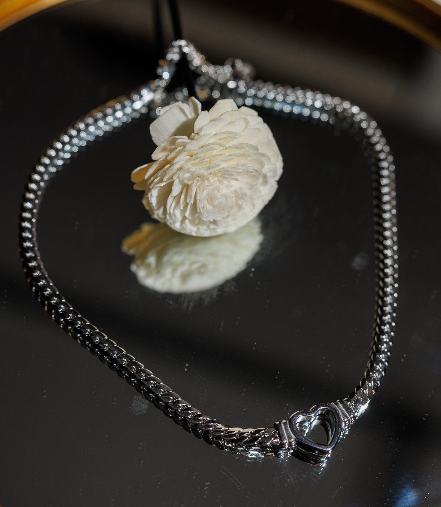 Stainless steel Cuban chain necklace featuring a hollow heart centerpiece. This elegant and durable piece combines timeless design with modern sophistication.