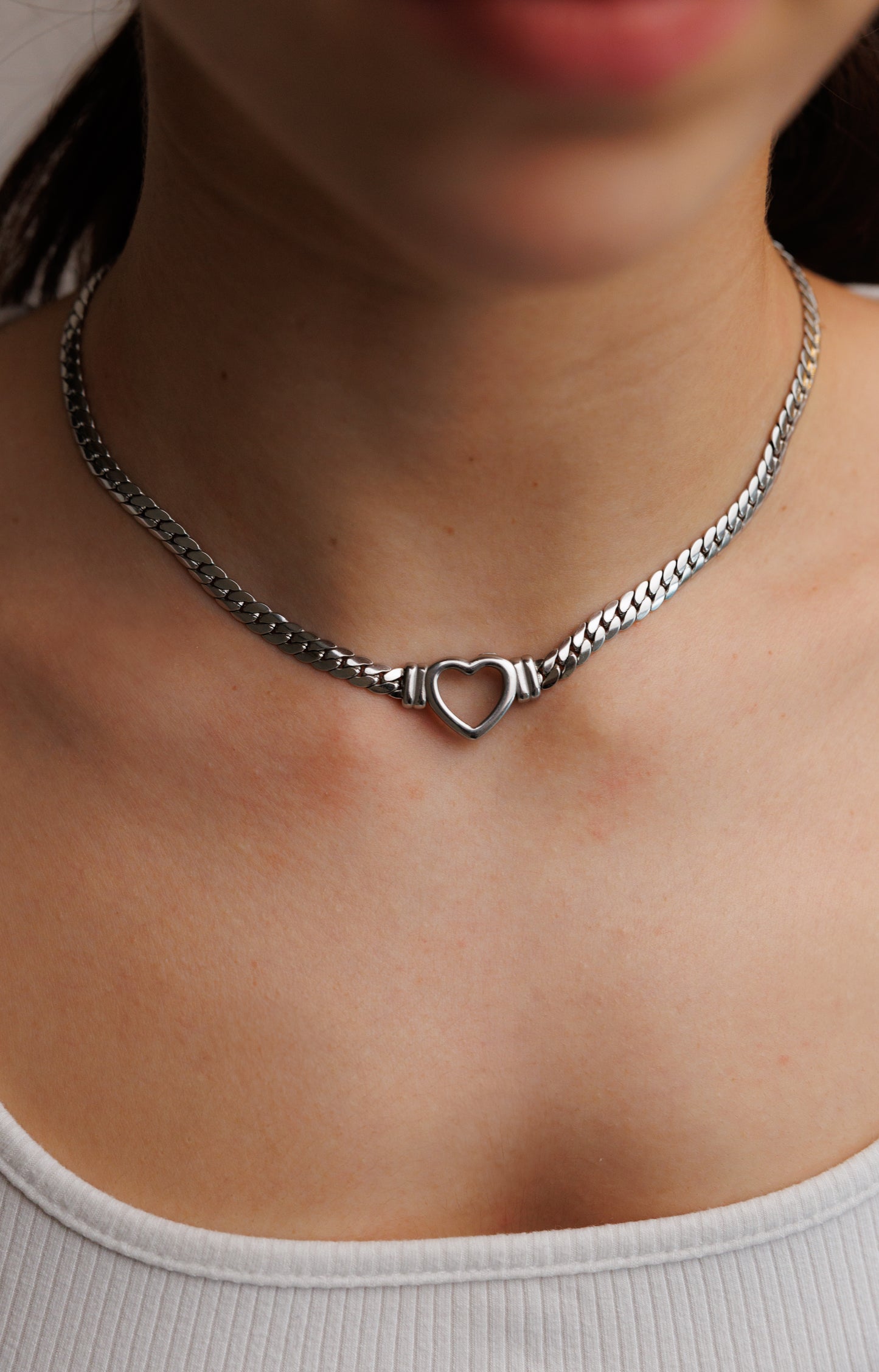 Stainless steel Cuban chain necklace featuring a hollow heart centerpiece. This elegant and durable piece combines timeless design with modern sophistication.
