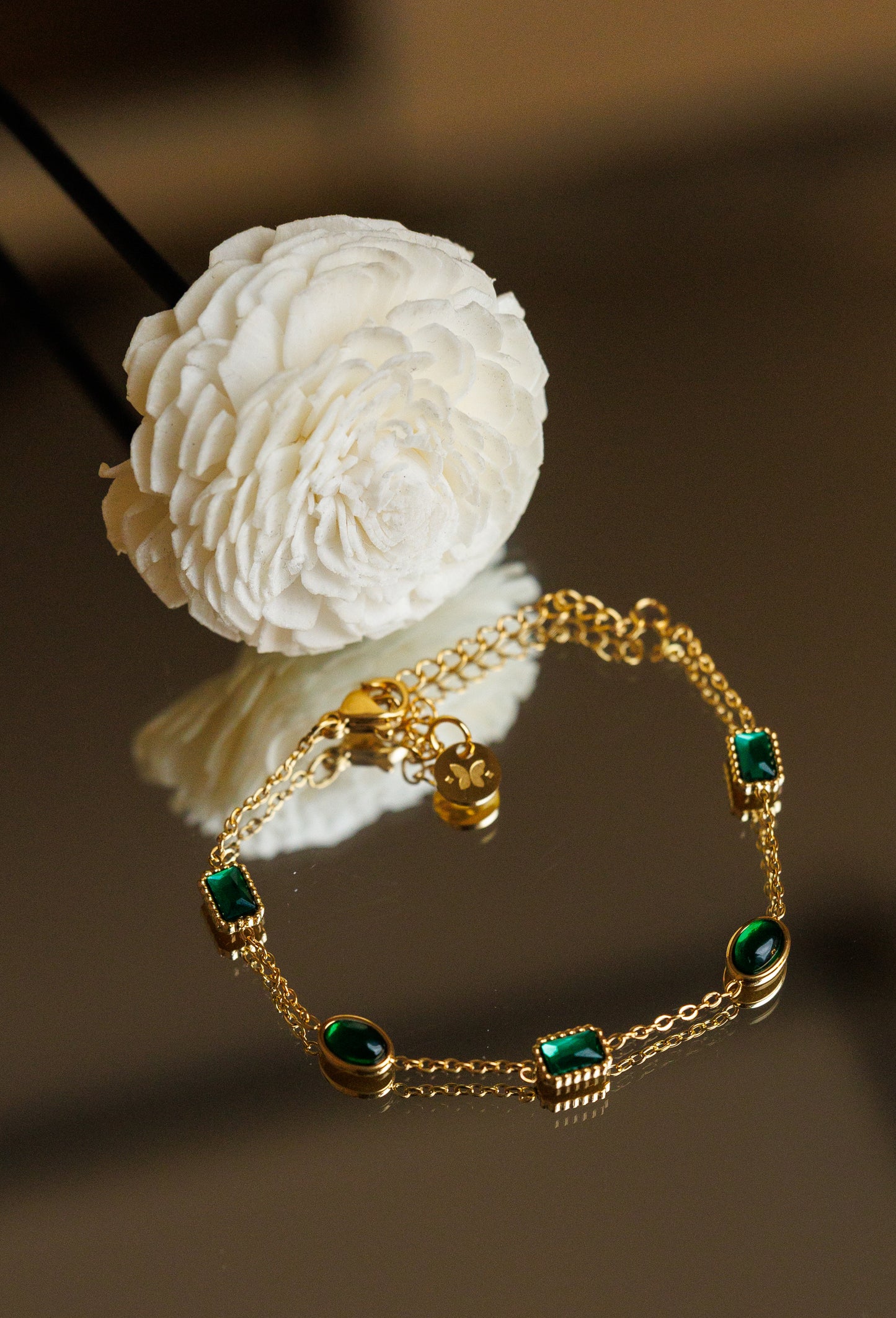 “Elegant and timeless, this 18k gold-plated bracelet features a stunning green emerald zircon centerpiece, accompanied by two matching green accents for added charm.