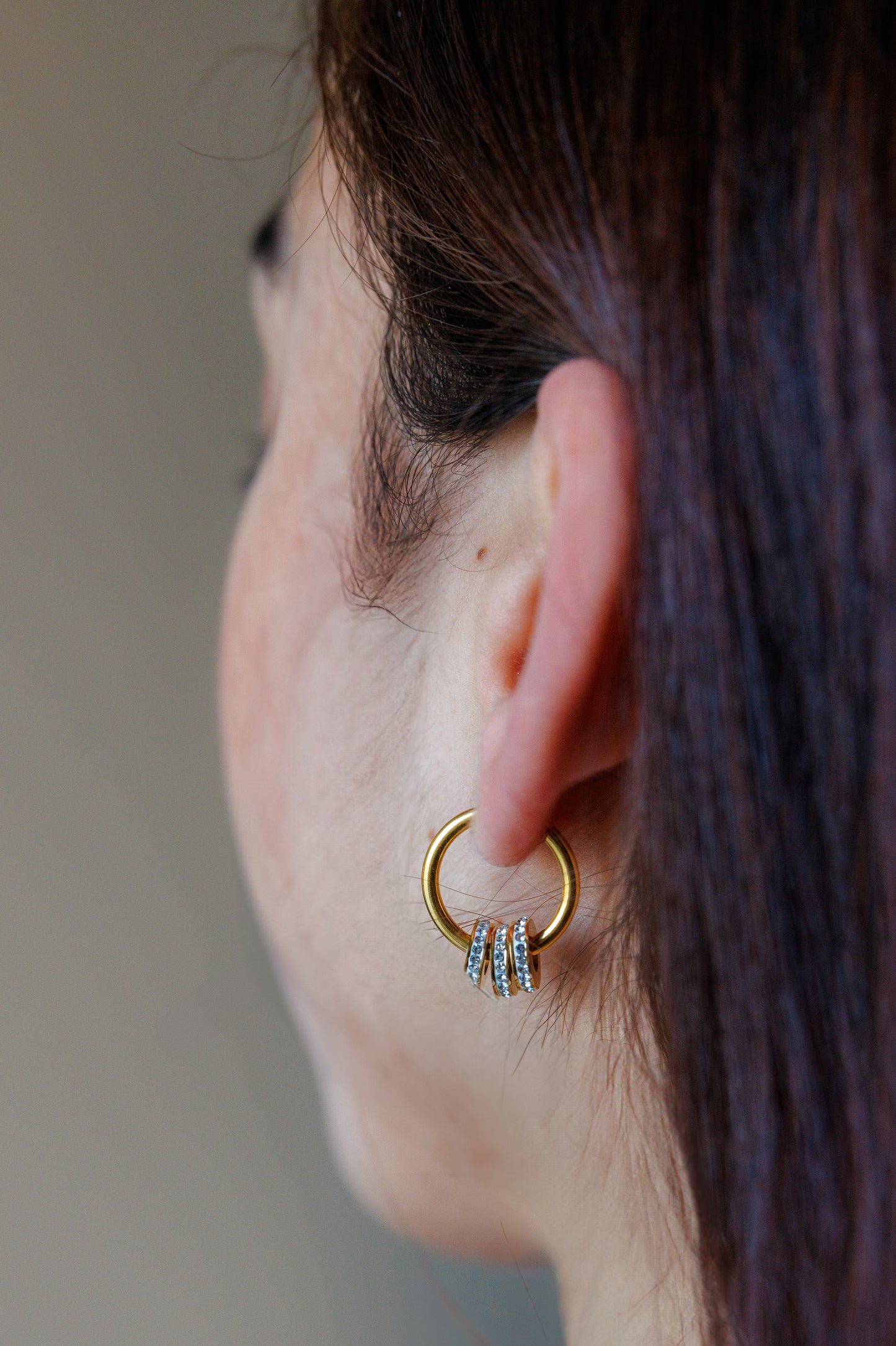 These stainless steel earrings feature a gold-plated design and are waterproof. The set includes three circles adorned with cubic zirconia and features a round drop design.