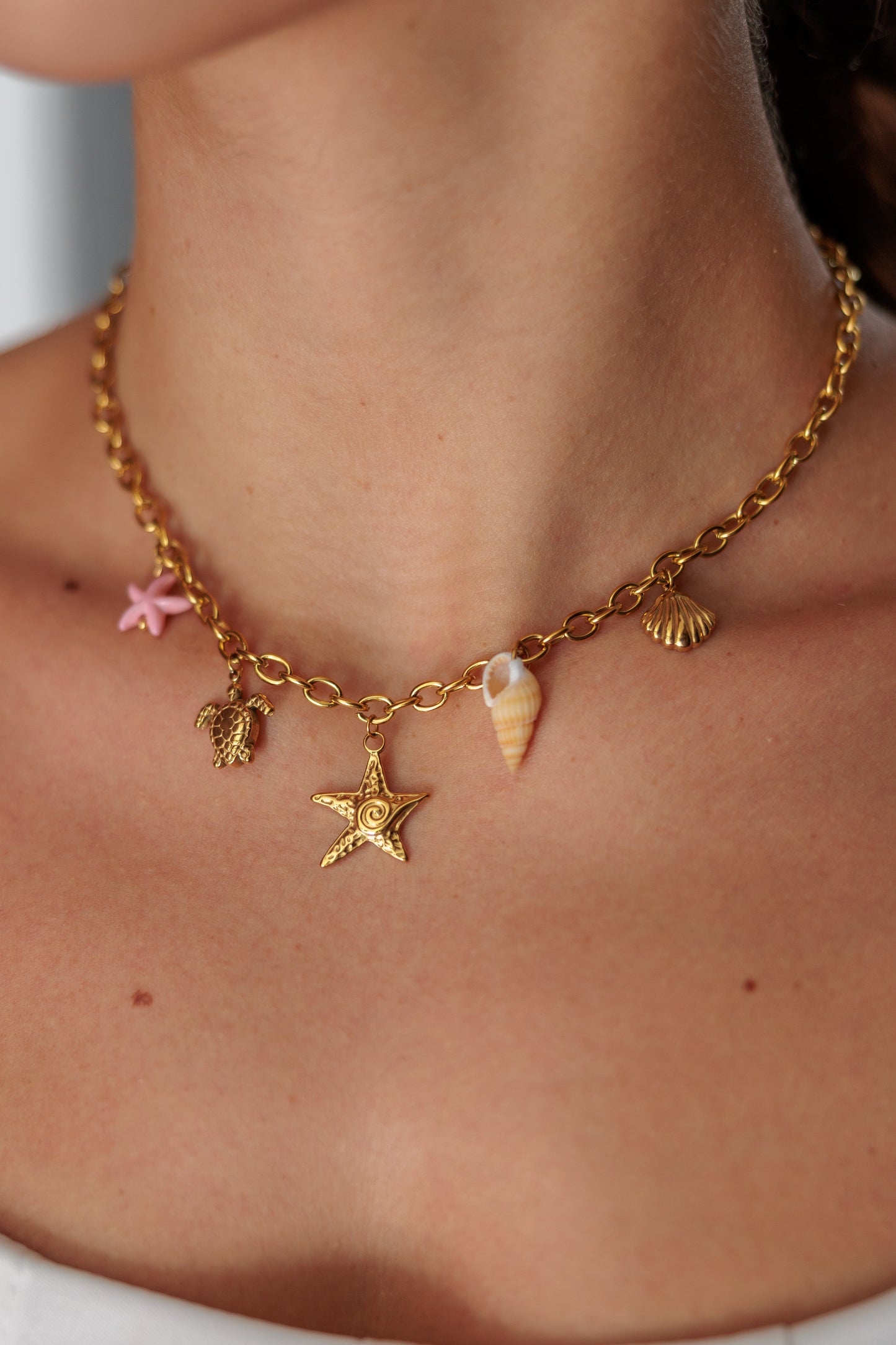necklace withocean charms — starfish, turtle, shell, and small beads.