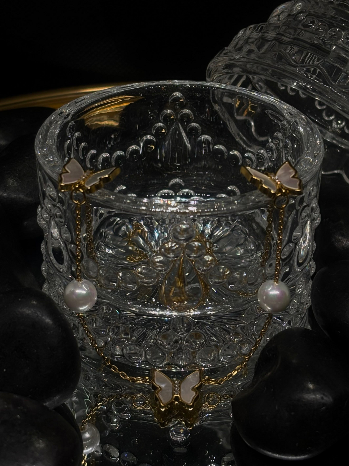Round pearl necklace features an elegant butterfly design.