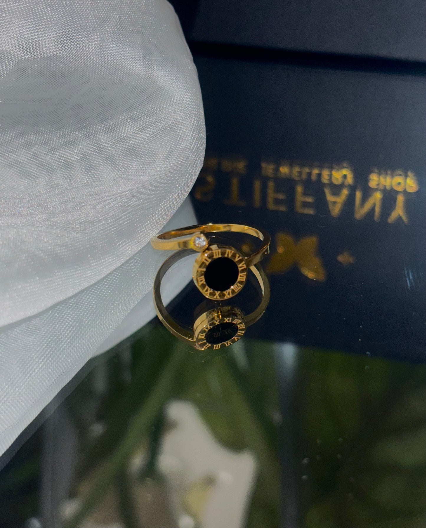 This exquisite ring showcases a timeless design, featuring delicately carved Roman letters and a shimmering zircon inlay, all crafted with 18k gold plating.