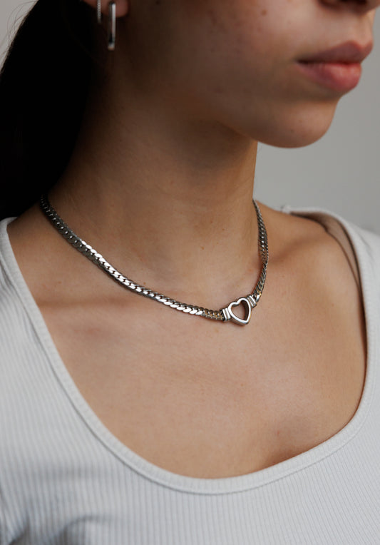 Stainless steel Cuban chain necklace featuring a hollow heart centerpiece. This elegant and durable piece combines timeless design with modern sophistication.