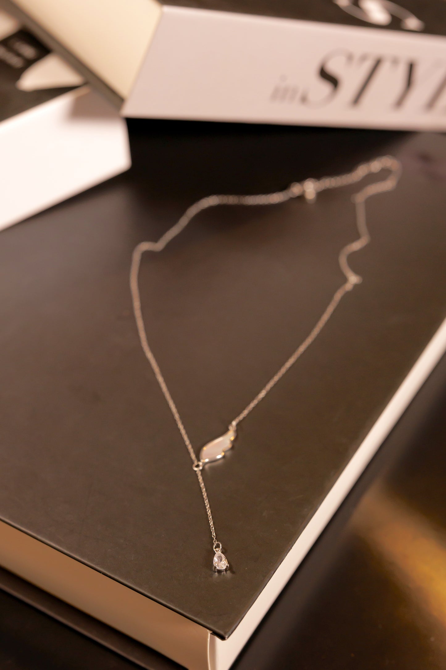 Necklace with seashell wing and zircon in the bottom