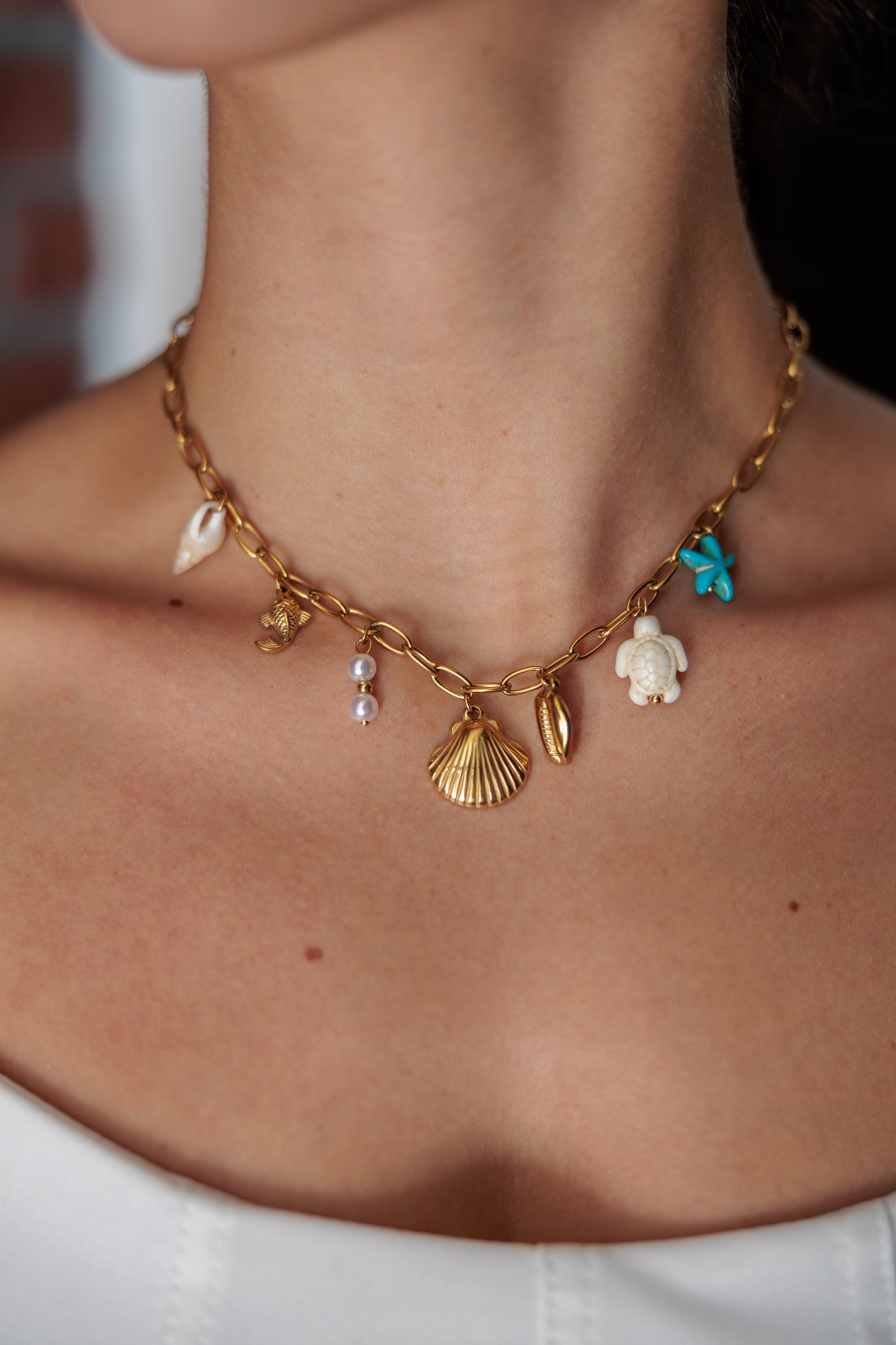 necklace with playful beach charms — shells, bluestarfish